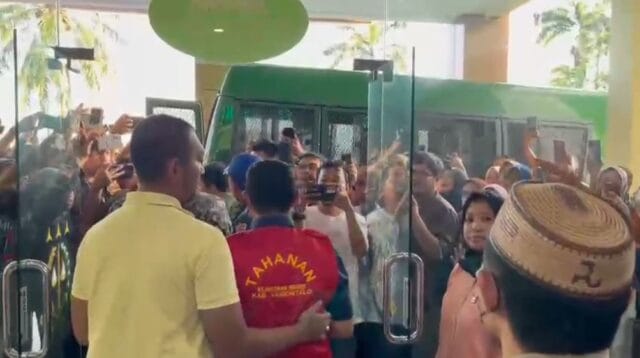 Tersangka kasus korupsi tengah bejalan keluar menuju mobil tahanan Kejaksaan Negeri Kabupaten Gorontalo, foto/aiimnews.com