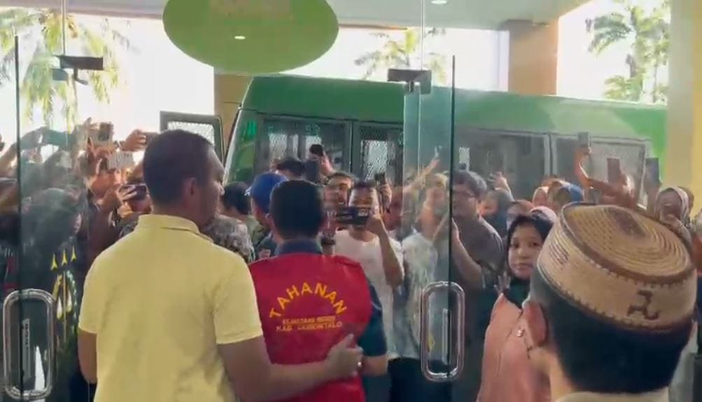 Tersangka kasus korupsi tengah bejalan keluar menuju mobil tahanan Kejaksaan Negeri Kabupaten Gorontalo, foto/aiimnews.com