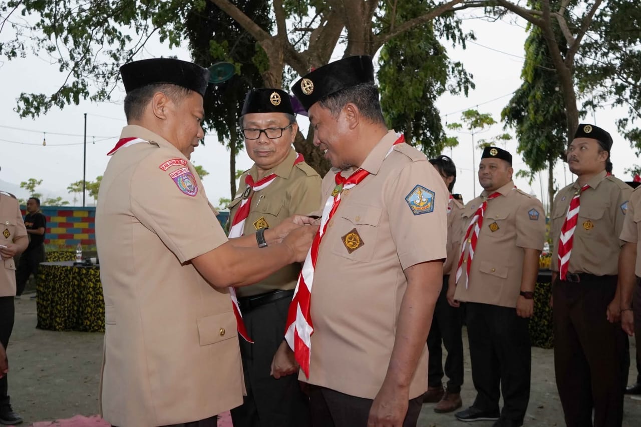 Ketua Kwarcab Kabupaten Gorontalo, Roman Nasaru memakaikan tanda jabatan kepada ketua Pimsaka Bahari, Haris S Tome