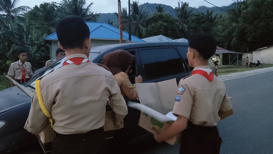 Anggota Saka Bahari Kabupaten Gorontalo tengah membagikan takjil kepada pengguna jalan, foto/Ist