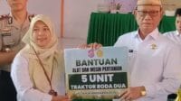 Bupati Ismet Mile menyerahkan bantuan alat pertanian, foto/Istimewa