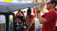 Kepala Bank Mandiri Cabang Gorontalo, Warham Syahrani tengah berbagi bendera kepada tukang bentor, foto/istimewa